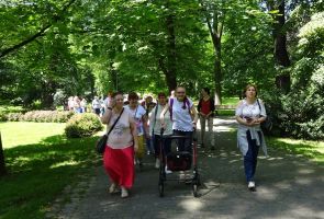 Grupa wycieczkowa idąca przez park.