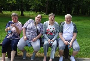 Mieszkanki siedzące na ławce przed tężnią.